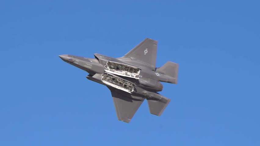 Flying in slow motion with its underside exposed, an F35 fighter jet.