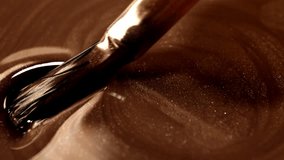 Metallic bronze cosmetic pigment being spread with brush in slow motion, luxury makeup shimmer texture, nail polish fluid swirl, glossy bronze liquid background for beauty product ads - Powered by Shutterstock - Get 15% off with code: PIKWIZARD15
