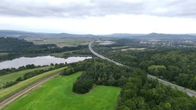 Aerial drone view of railway disappearing into tunnel beneath high-speed overpass, showing layered transport infrastructure, perspective depth, and striking contrast of motion corridors. - Powered by Shutterstock - Get 15% off with code: PIKWIZARD15