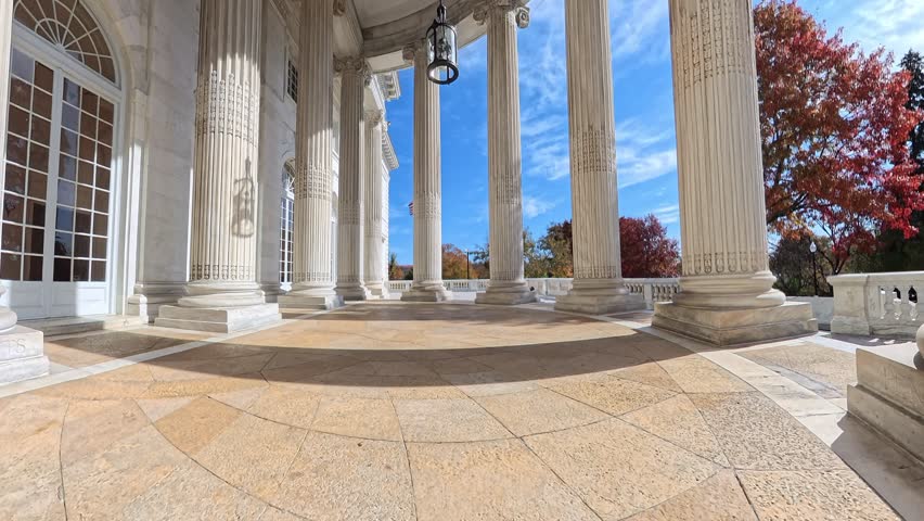 Grand marble columns and the neoclassical style of a historic building in Washington. The camera pans upward.
