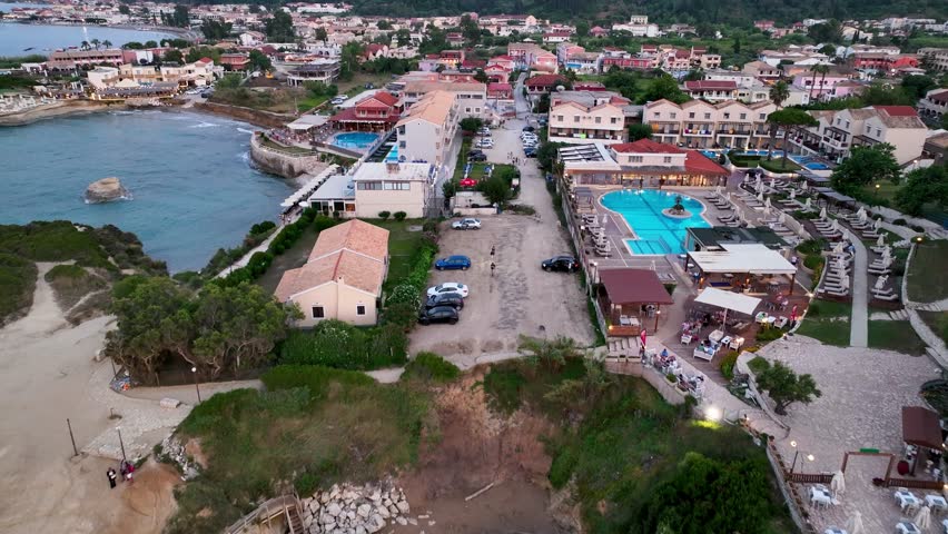 Aerial drone reveal shot pulling back from Sidari village to show the narrow, iconic channel of Canal d'Amour, Corfu, Greece at dusk
