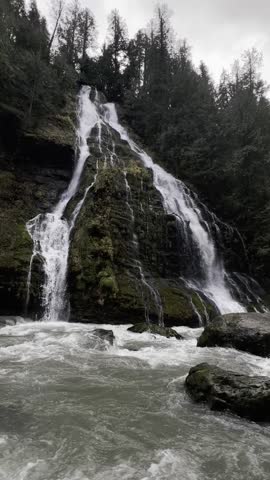 Dramatic Cascading Waterfall and Rushing River in a Dark, Moody Forest Landscape