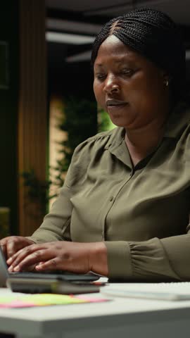 Vertical Video Excited beaming black woman receiving good news for an opportunity, woman being proud of breakthrough and accomplishment in the office after hours. Delighted about contract deal. Camera