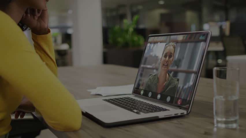 Woman listening as peer speaking, laptop overlay showing code and progressbar advancing in tech. Coworking, collaboration, focus, modern, productivity, digital, office