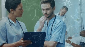 Doctor showing tablet and briefing peer, network icons overlaying scene, guiding clinical decisions. Collaboration, hospital, teamwork, data, telemedicine, monitoring, device - Powered by Shutterstock - Get 15% off with code: PIKWIZARD15