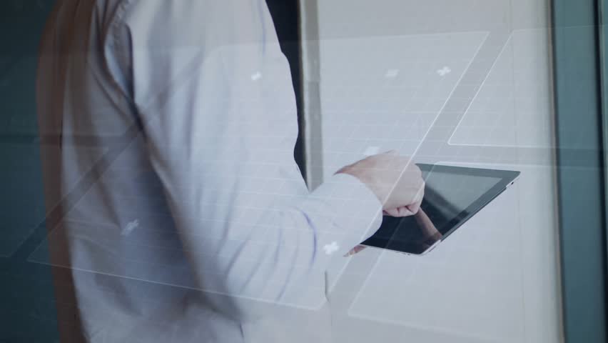 Businessman tapping tablet, animating HUD while reviewing stats and swiping, glancing toward window. Office, professional, glass, interface, touchscreen, device, corporate - Powered by Shutterstock - Get 15% off with code: PIKWIZARD15