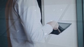 Businessman tapping tablet, animating HUD while reviewing stats and swiping, glancing toward window. Office, professional, glass, interface, touchscreen, device, corporate - Powered by Shutterstock - Get 15% off with code: PIKWIZARD15