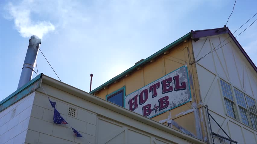 Low angle shot of a hotel pub with a smoking chimney, in Nimmitabel, snowy Monaro region, NSW Australia