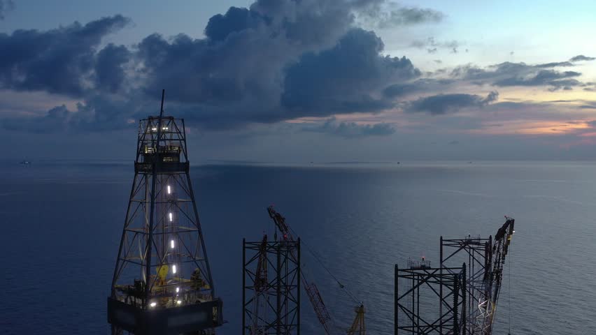 Aerial view of offshore jack up rig and offshore platform during sunset for oil and gas exploration and production. 
