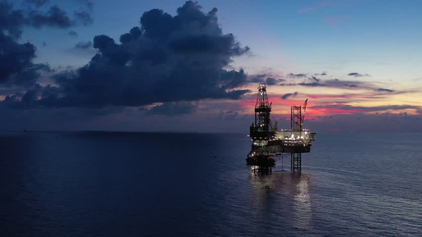Aerial view of offshore jack up rig and offshore platform during sunset for oil and gas exploration and production. 
