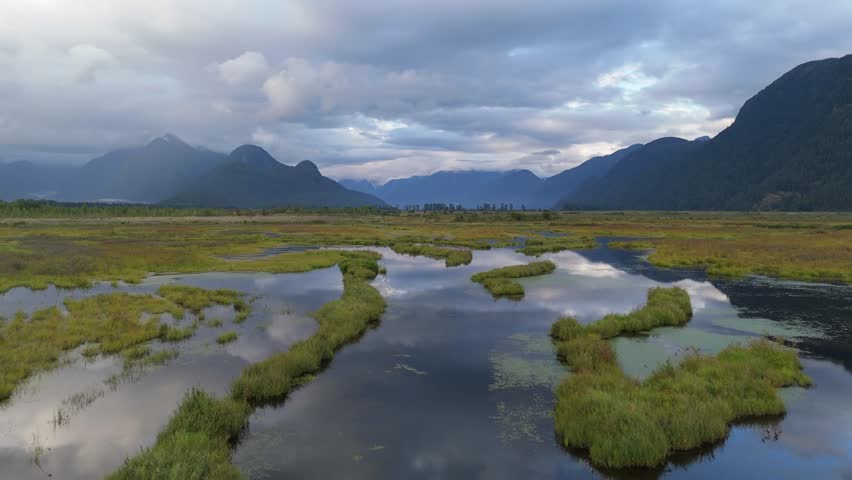 Aerial View of Serene Wetlands and Majestic Mountains Reflecting in Calm Water, British Columbia, Canada
