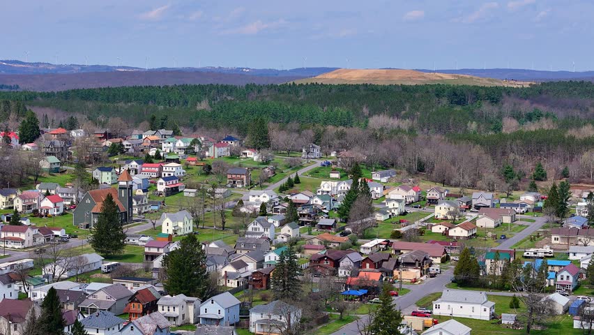 Colorful houses in hilly Davis, West Virginia with forested backdrop in spring, USA