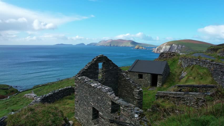Epic Ireland drone flying over ruins of farm with blanket Islands Slea head Kerry in autumn stunning coastal landscape
