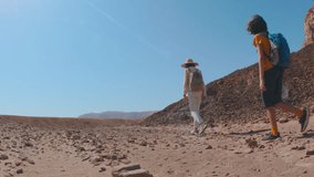 Two active backpackers stroll through the desert against a blue sky. Mother and child on a hike. Summer camp. Timna National Park. The child is actively spending time. Trekking and hiking. - Powered by Shutterstock - Get 15% off with code: PIKWIZARD15