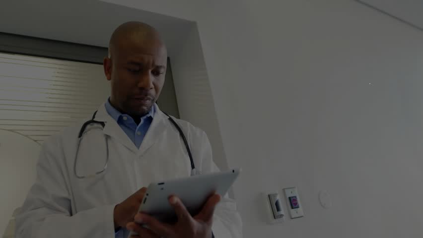 Male doctor using tablet in clinical environment, showcasing user-profile network graphics. Healthcare, telemedicine, technology, professionalism, connectivity, innovation, digital - Powered by Shutterstock - Get 15% off with code: PIKWIZARD15