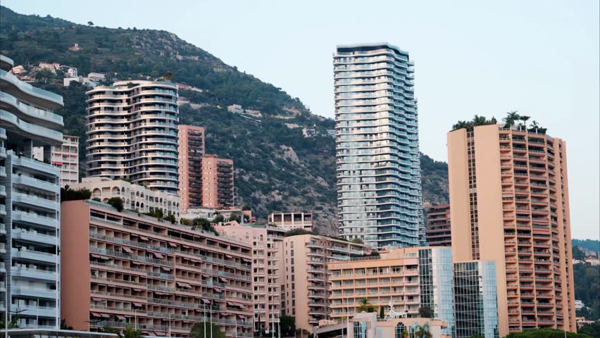 Aerial view of Monaco’s skyline in daylight, highlighting luxury buildings, coastline, and the city’s glamorous urban landscape near the sea.