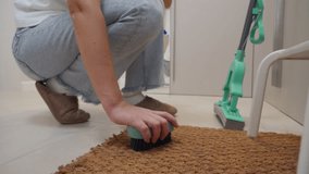A Fresh Welcome: Woman Deep Cleans Entryway Doormat with a Scrub Brush. - Powered by Shutterstock - Get 15% off with code: PIKWIZARD15