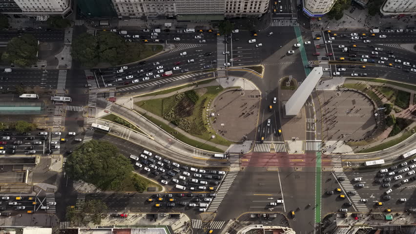 Aerial hyperlapse of the Obelisk and 9 de Julio Avenue in Buenos Aires with intense traffic and city movement.