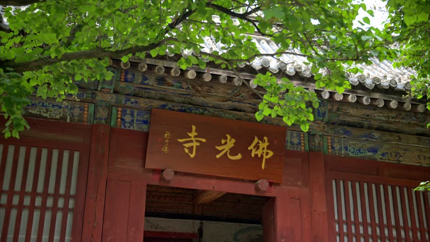 Traditional Chinese temple entrance with ornate wooden architecture and golden calligraphy signage in Foguang Temple, Xinzhou, Shanxi Province, China.