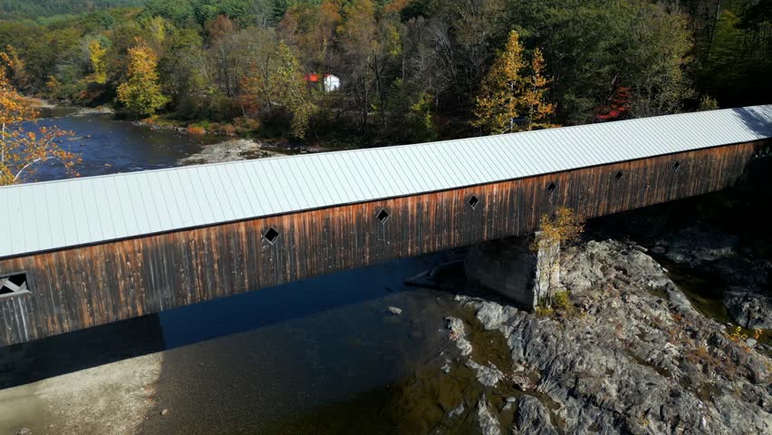 Drone ascend tilting down above beach and West River Covered Bridge, West Dummerston Vermont