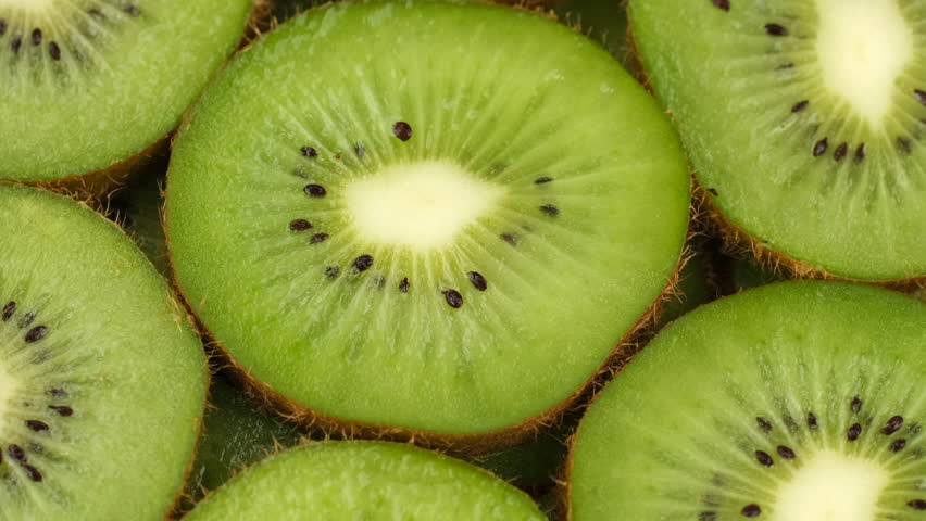 Zoom frame Sliced kiwi fruits top view, rotation. Fresh and healthy food concept
