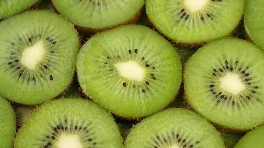 Zoom frame Sliced kiwi fruits top view, rotation. Fresh and healthy food concept