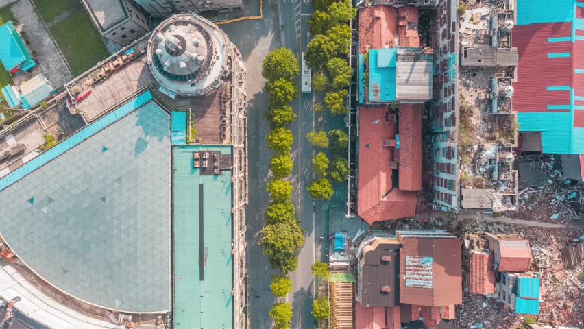 Aerial view of urban development in Wuhan showing mixed architecture, tree-lined streets, construction sites, and city infrastructure from above
