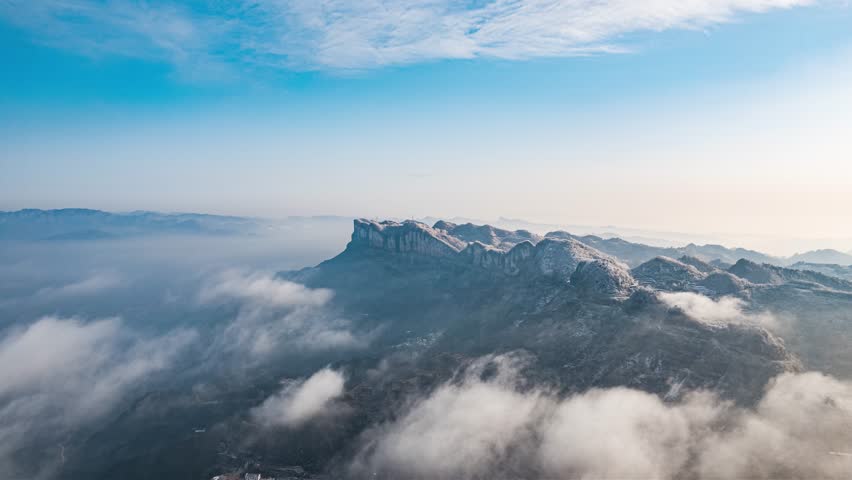 Magnificent Three Gorges scenery along Yangtze River with snowy mountain cliffs emerging through clouds in time lapse view, showcasing dramatic Chinese landscape and natural beauty.