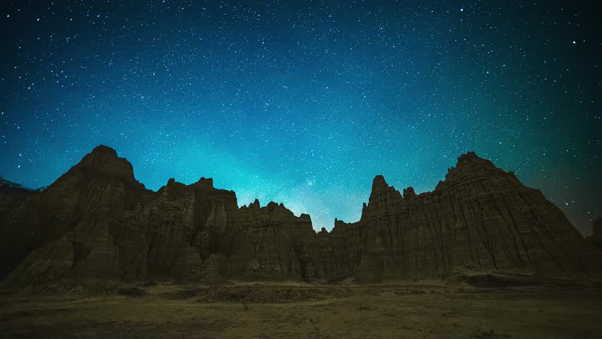 Spectacular Milky Way galaxy stretching across starry night sky above dramatic rock formations in Yunnan Province, China, creating stunning astrophotography landscape.