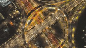 Stunning aerial view of illuminated highway interchanges at night showing flowing traffic light trails and complex road infrastructure from elevated perspective - Powered by Shutterstock - Get 15% off with code: PIKWIZARD15