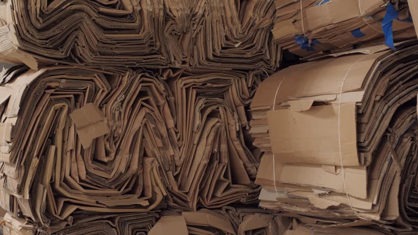 Piles of compressed cardboard boxes ready for paper recycling and waste management at a warehouse