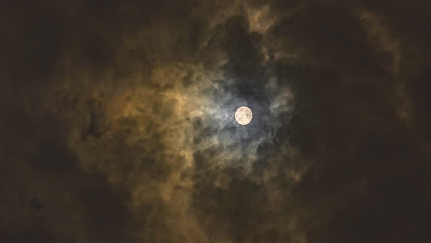 Beautiful full moon shining through dramatic dark clouds on a windy night, creating atmospheric and moody celestial scenery with golden light illumination. - Powered by Shutterstock - Get 15% off with code: PIKWIZARD15