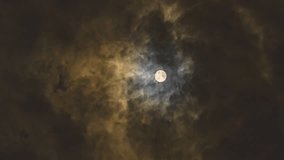 Beautiful full moon shining through dramatic dark clouds on a windy night, creating atmospheric and moody celestial scenery with golden light illumination. - Powered by Shutterstock - Get 15% off with code: PIKWIZARD15