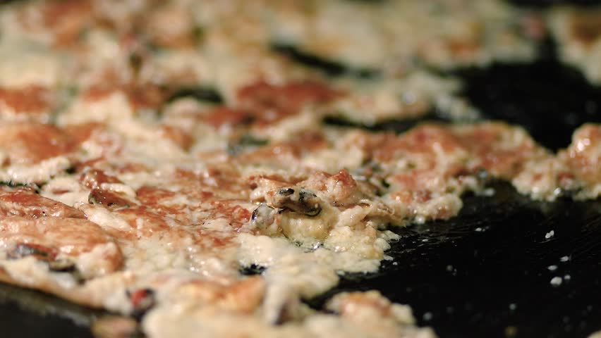 Thai crispy oyster omelet sizzling on a hot pan, a popular street food with tempting aroma in the lively night market