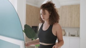 Young curly-haired woman measuring waist with tape, satisfied with diet results - Powered by Shutterstock - Get 15% off with code: PIKWIZARD15