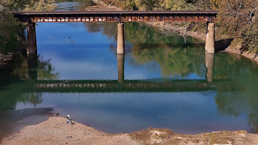 Aerial view of the Rail Bridge over the Meramec River with a sandy bank and light reflecting on the water