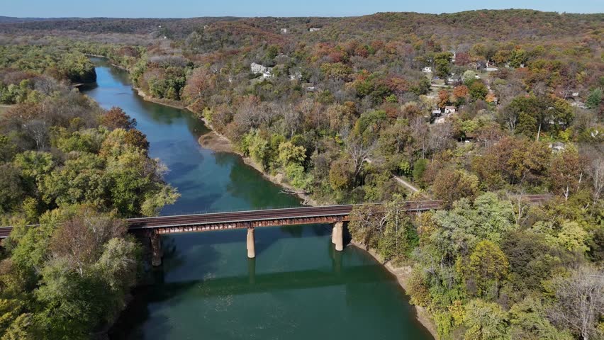 Aerial view of the Rail Bridge over the Meramec River surrounded by vibrant autumn foliage, creating a stunning contrast of colors, Ballwin Beach, Missouri, United States.