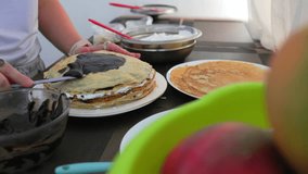 Side view of woman decorating layered crepe cake with chocolate ganache using a spatula - Powered by Shutterstock - Get 15% off with code: PIKWIZARD15