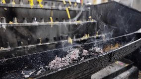 Candlelight at Wat Pho, ashes and smoke on a low altar, creating a serene spiritual ambiance. - Powered by Shutterstock - Get 15% off with code: PIKWIZARD15
