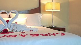 A luxurious romantic setup with “Happy Anniversary” spelled in rose petals on a bed, towel swans forming a heart, and soft lighting. Perfect for weddings, love celebrations, and resort romance. - Powered by Shutterstock - Get 15% off with code: PIKWIZARD15