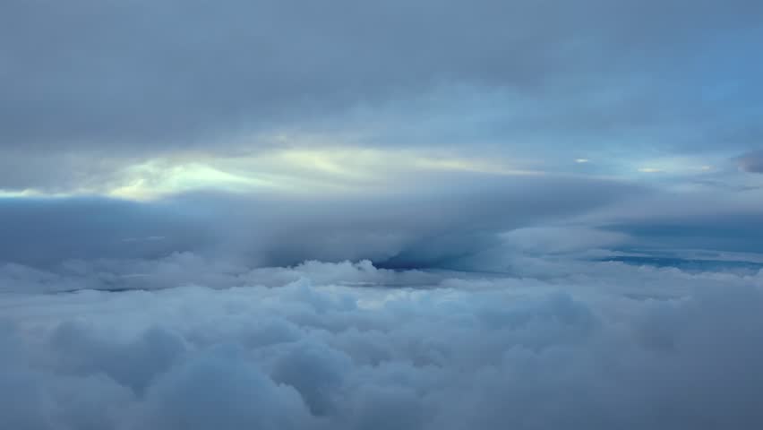Immersive pilot’s perspective from a jet cockpit flying between layers of stratus clouds, with a threatening storm cloud ahead in a dramatic sky.