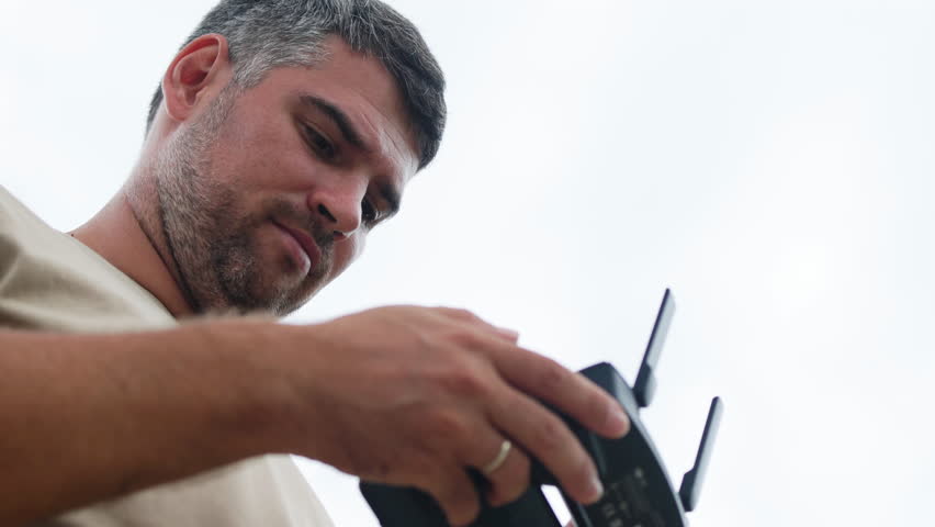 A portrait of a man focused on a drone controller.