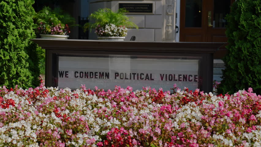 WE CONDEMN POLITICAL VIOLENCE Sign With Beautiful Pink and White Flowers. - wide shot