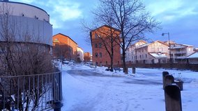 The old red brick buildings at the end of Krukmakargatan in Södermalm, Stockholm. The street is covered with snow on a sunny winter day. The trees outside the houses have bare branches in the winter. - Powered by Shutterstock - Get 15% off with code: PIKWIZARD15