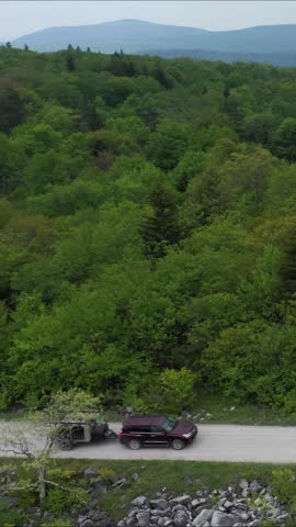 A camper navigates a gravel trail surrounded by lush green trees in the Monongahela National Forest, enjoying the serenity of the Appalachian landscapes.