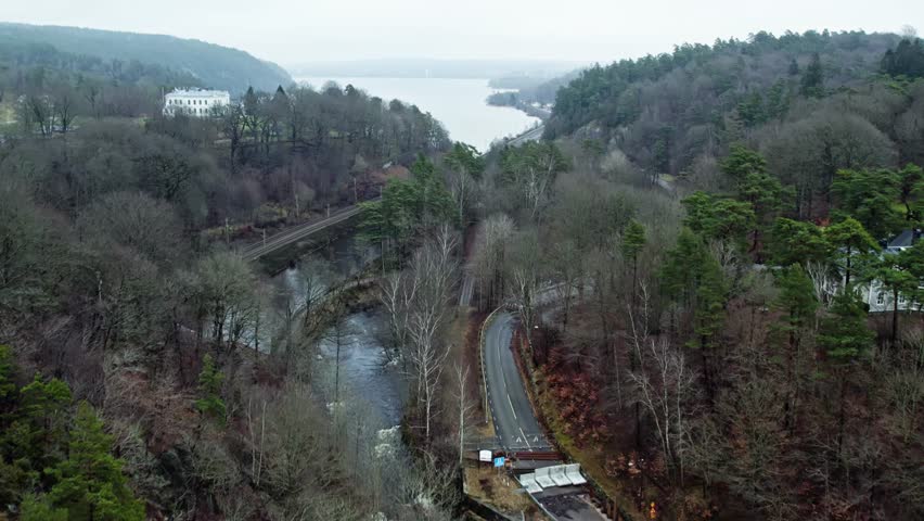 Drone aerial of Jonsered village and Save River near Gothenburg, Sweden, captured during a calm, misty morning in soft, diffused light.