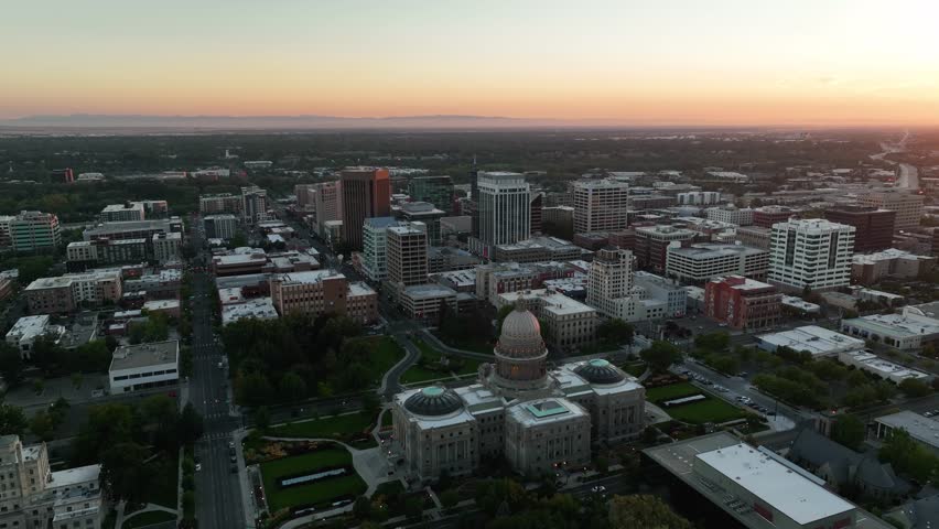 Aerial establishing shot of the Idaho State Capitol building in downtown Boise at sunset