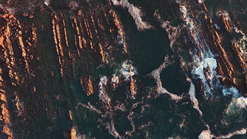 Waves and rocks on the coastlin at sunset with strong colors