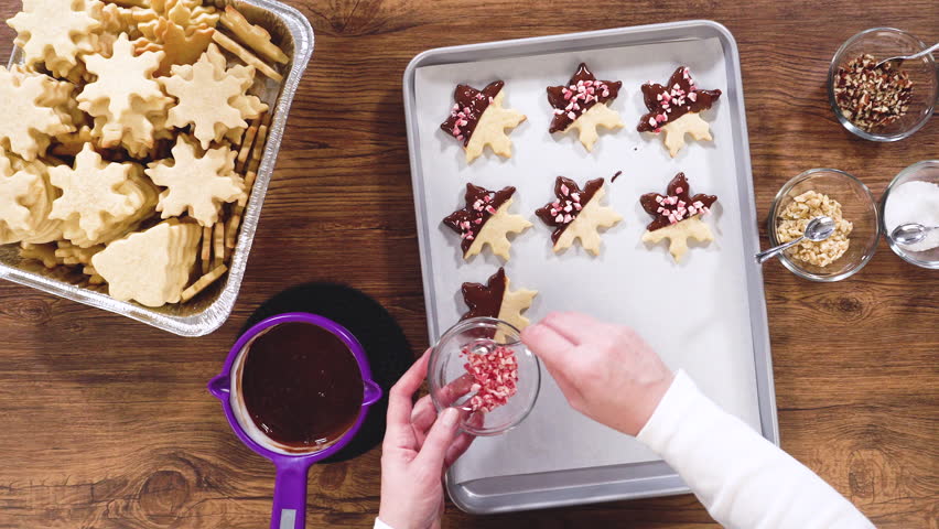 Flat lay. Preparing star-shaped cookies, half-dipped in chocolate, accented with peppermint chocolate chips for the holidays.