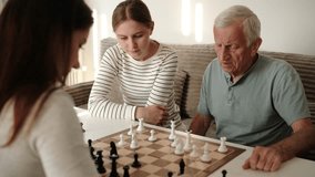 Grandfather Playing Chess With Granddaughters, Having Joy Together At Weekend - Powered by Shutterstock - Get 15% off with code: PIKWIZARD15